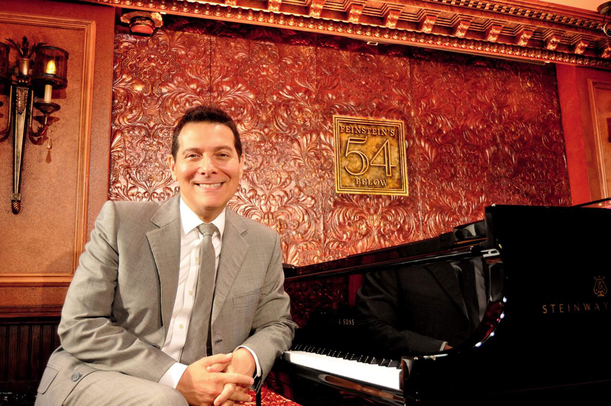 Michael Feinstein Onstage - Philip Romano Michael Feinstein sitting at the piano smiling