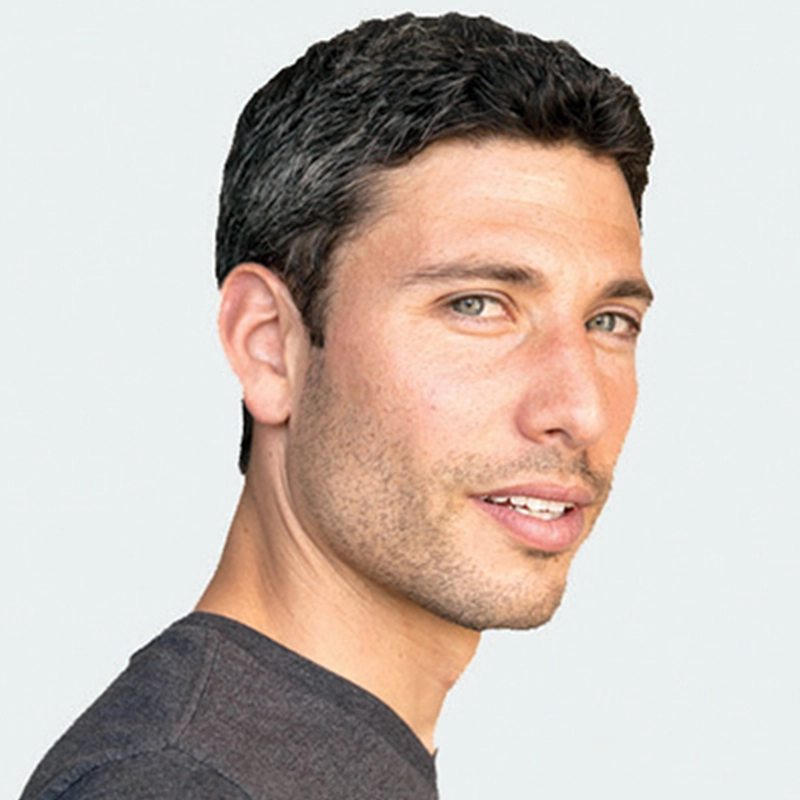 Profile headshot of Shira Averbuch, a man with short dark hair and stubble, looking toward the camera. He wears a dark t-shirt against a light background.