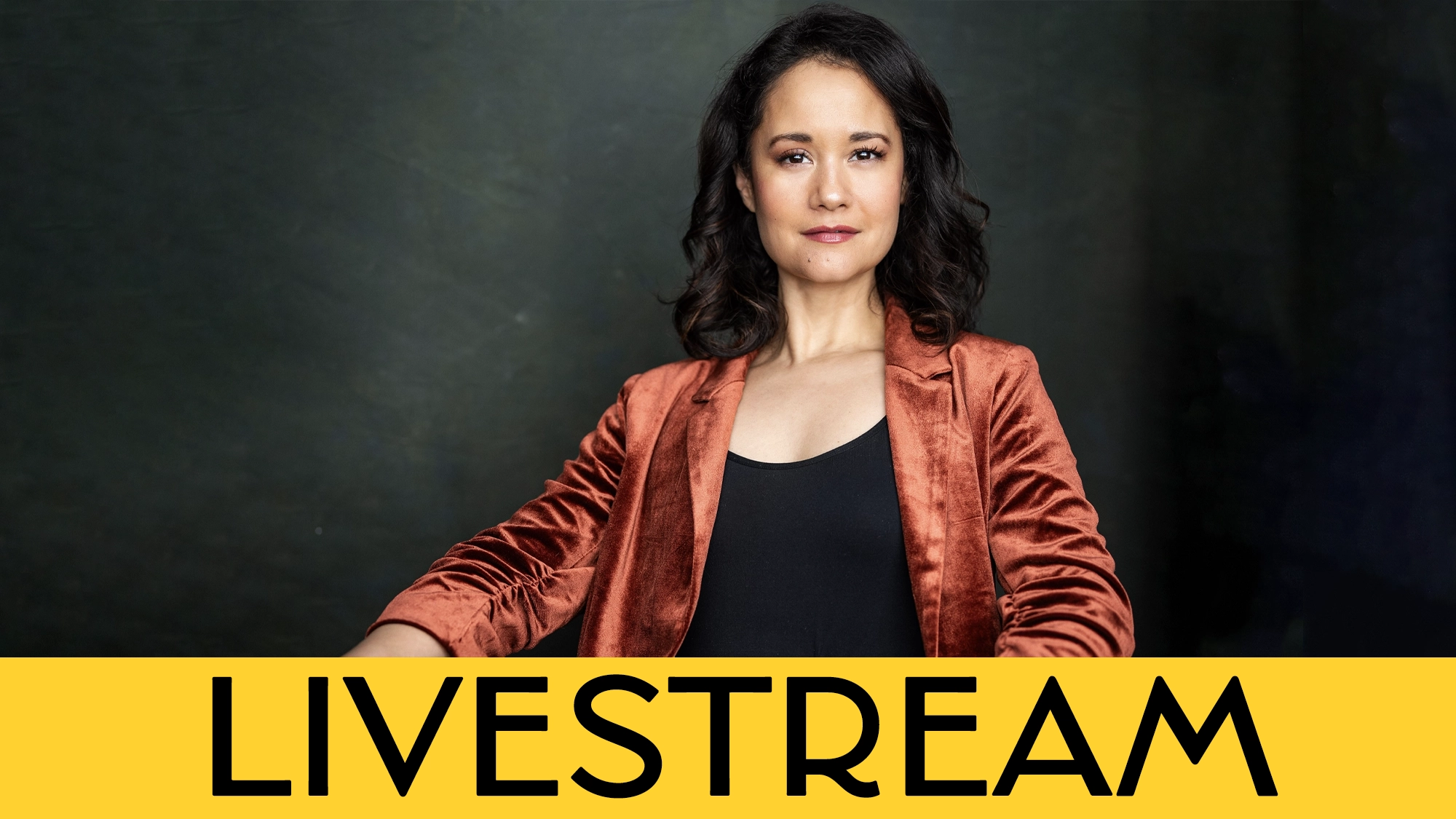 A person with wavy dark hair wears a copper-colored blazer over a black top, sitting confidently against a dark background. A bold yellow banner along the bottom displays Ali Ewoldt’s “LIVESTREAM” atop the words “When You Wish Upon A Star.”.