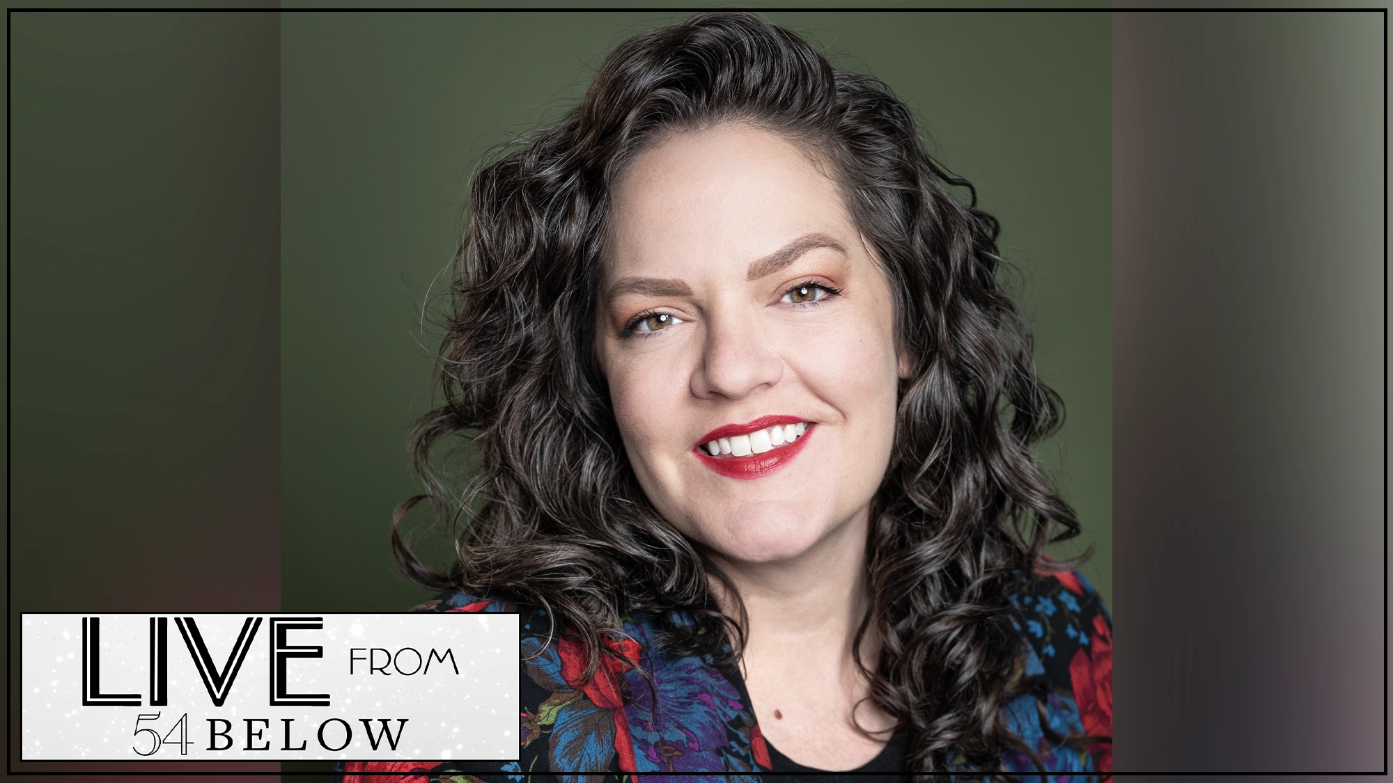 A woman with long, curly dark hair smiles at the camera. She wears a floral-patterned jacket and red lipstick, posed against a green background. In the bottom left, the 