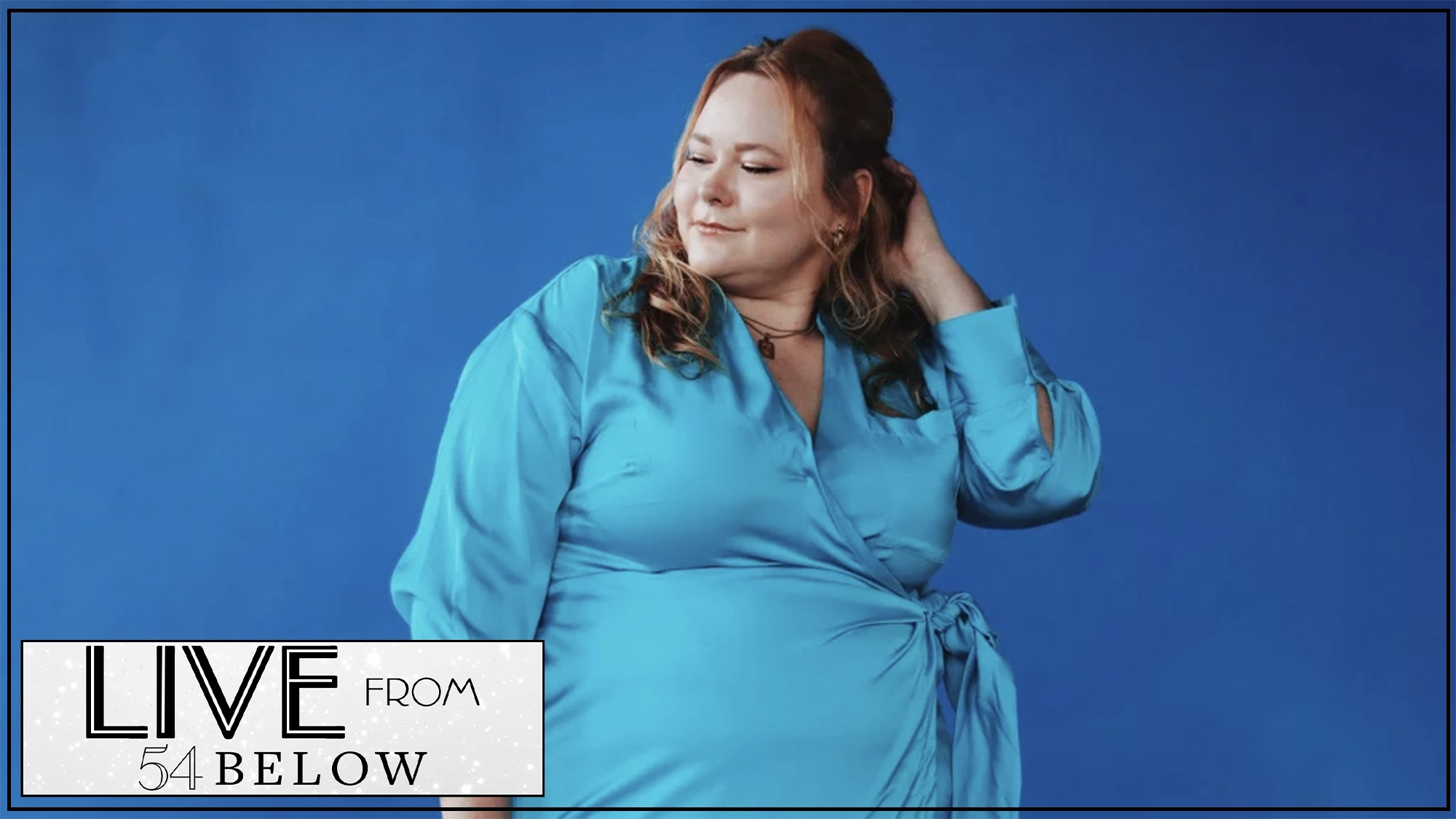 A woman in a bright blue wrap dress poses against a solid blue background, gazing down with a gentle smile and one hand touching her hair. In the bottom left corner, there is a graphic that reads “LIVE from 54 BELOW” in bold black and white text.