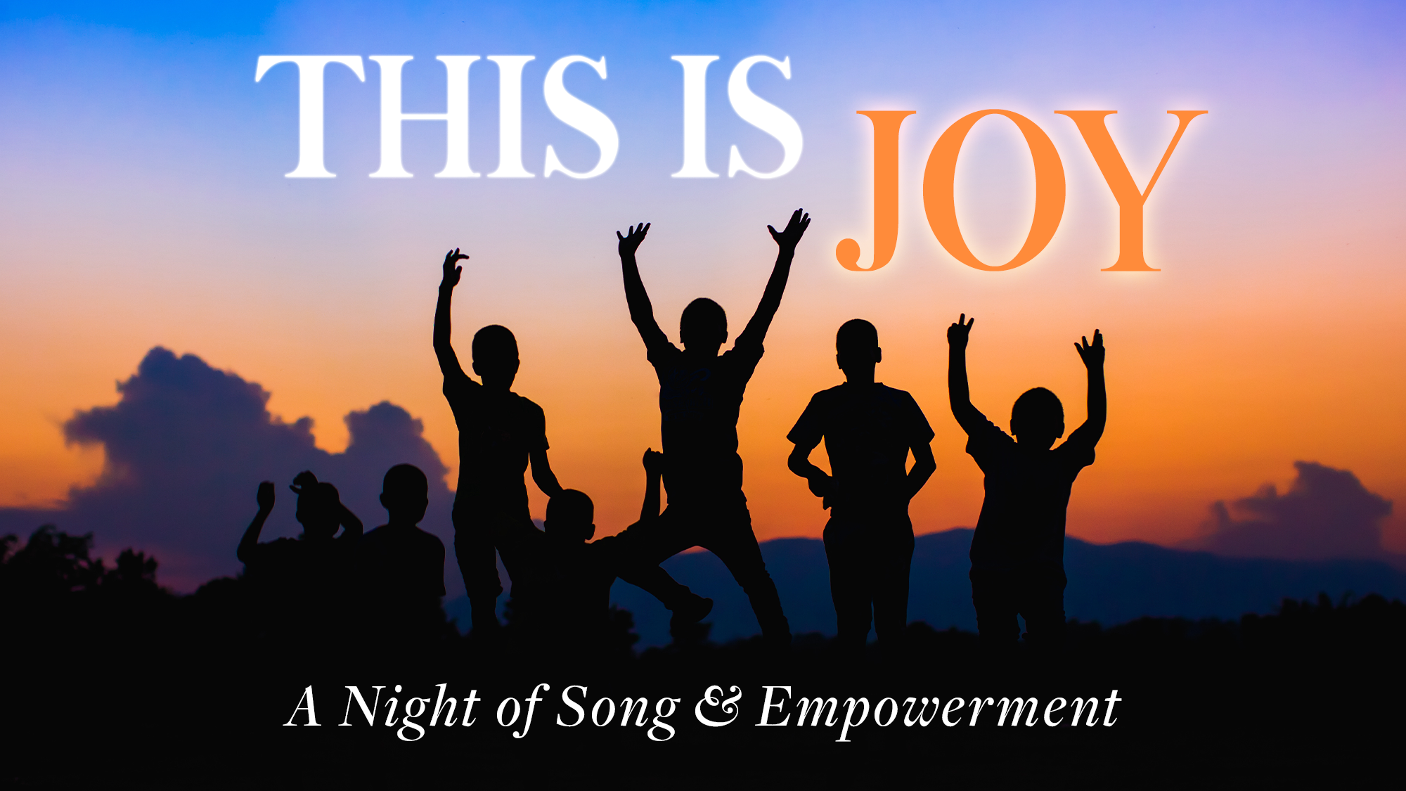 Silhouettes of joyful children jumping and raising their arms against a colorful sunset sky. Large text reads “THIS IS JOY” with smaller text below: “A Night of Song & Empowerment.” The mood is celebratory and filled with song and empowerment.