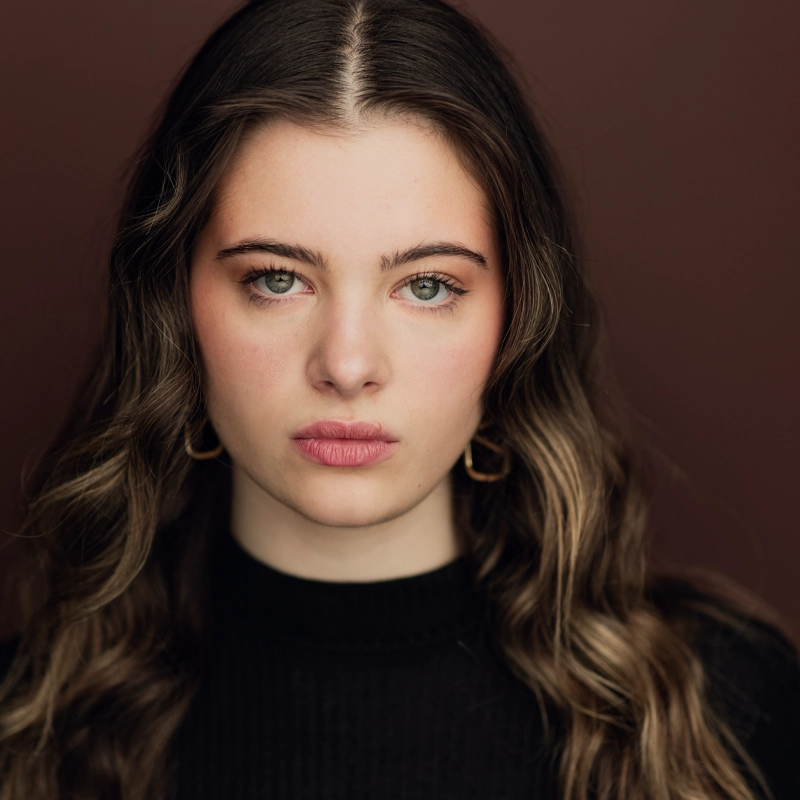 Sarah DeMarco, a woman with long hair, is seen wearing a black turtleneck.