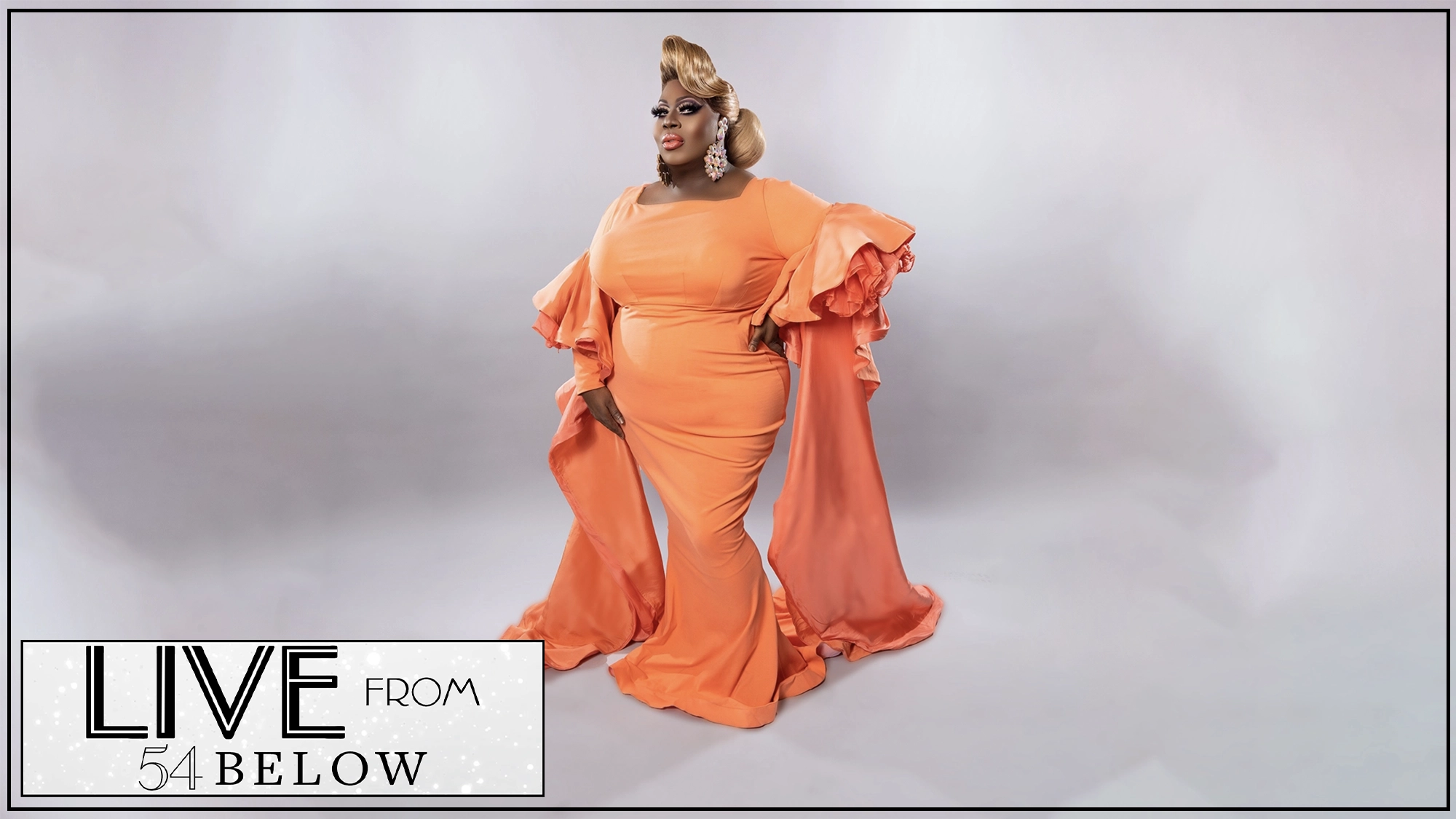 A person wearing a glamorous, flowing orange gown with dramatic, ruffled sleeves poses confidently against a soft gray backdrop. Channeling Latrice Royale, they have styled blonde hair and statement earrings. The corner reads “LIVE FROM 54 BELOW.”.