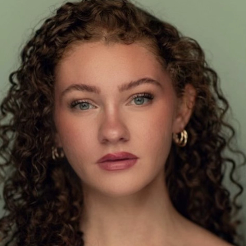 A woman with curly brown hair.