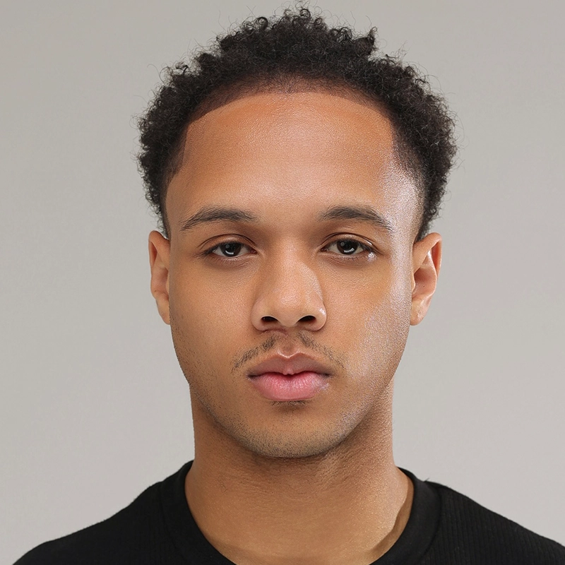 Gabe Woodard, a young man with short, curly dark hair and trimmed facial hair, looks directly at the camera. He has a neutral expression, medium skin tone, and is wearing a black crew-neck shirt against a plain light gray background.