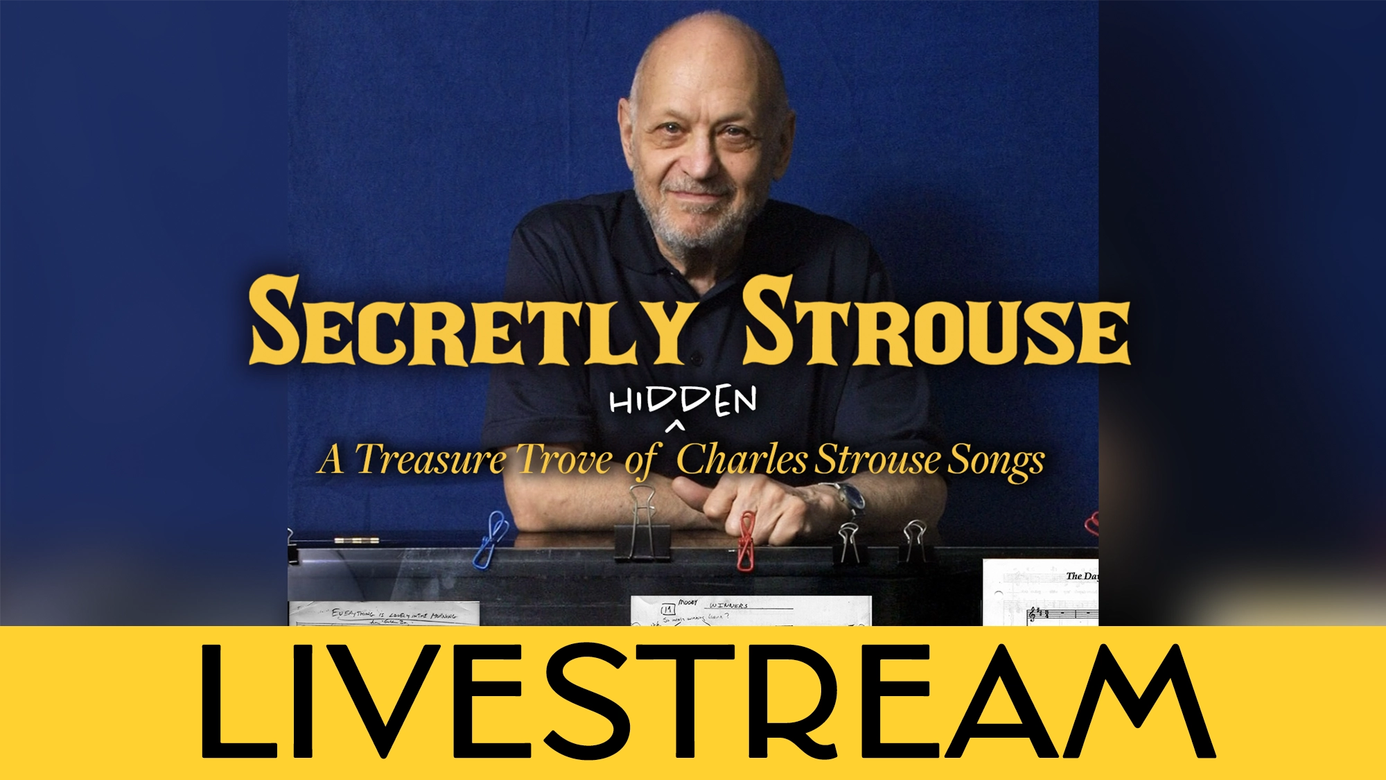 A bald man with a beard smiles slightly, resting his arms on a piano with sheet music. Yellow text reads: 