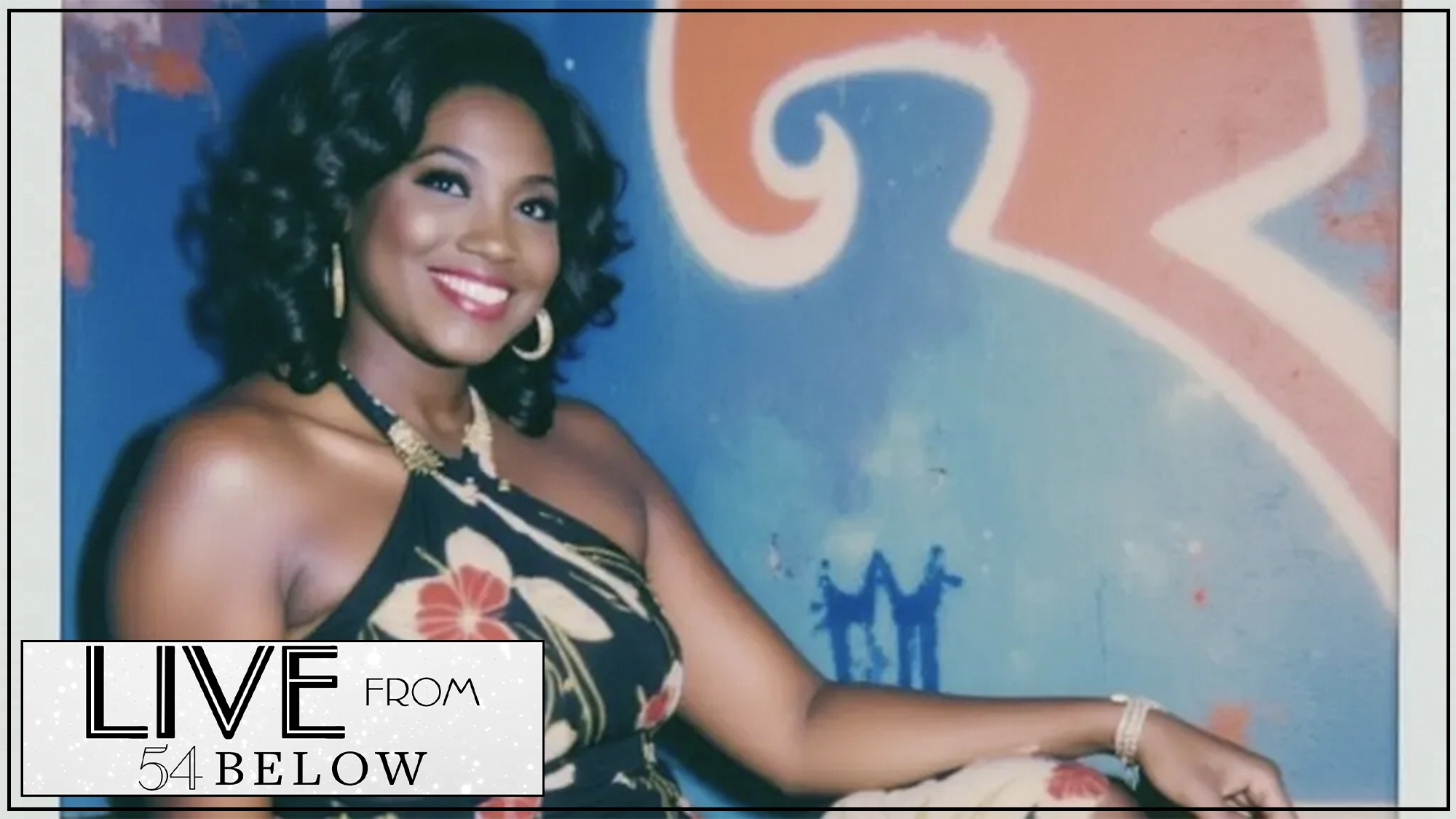 A smiling woman with curly dark hair, reimagined in a floral dress and gold jewelry, sits against a blue and orange abstract graffiti wall. In the bottom left, a white and black graphic reads, 