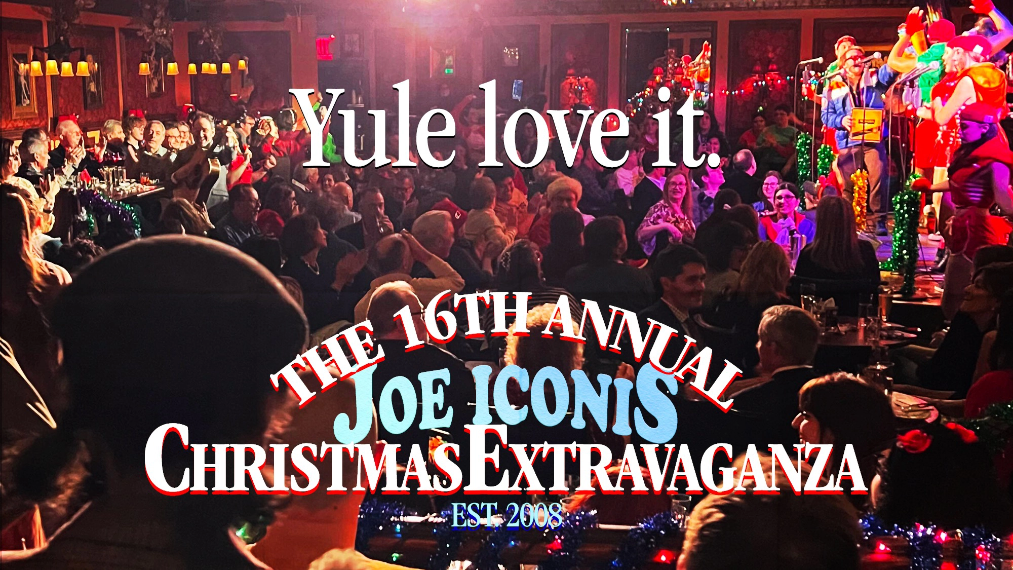 A festive, crowded theater with holiday decorations and performers on stage. Large white text reads, “Yule love it.” Below, red and blue text announces “The 16th Annual Joe Iconis Christmas Extravaganza EST. 2008.”.