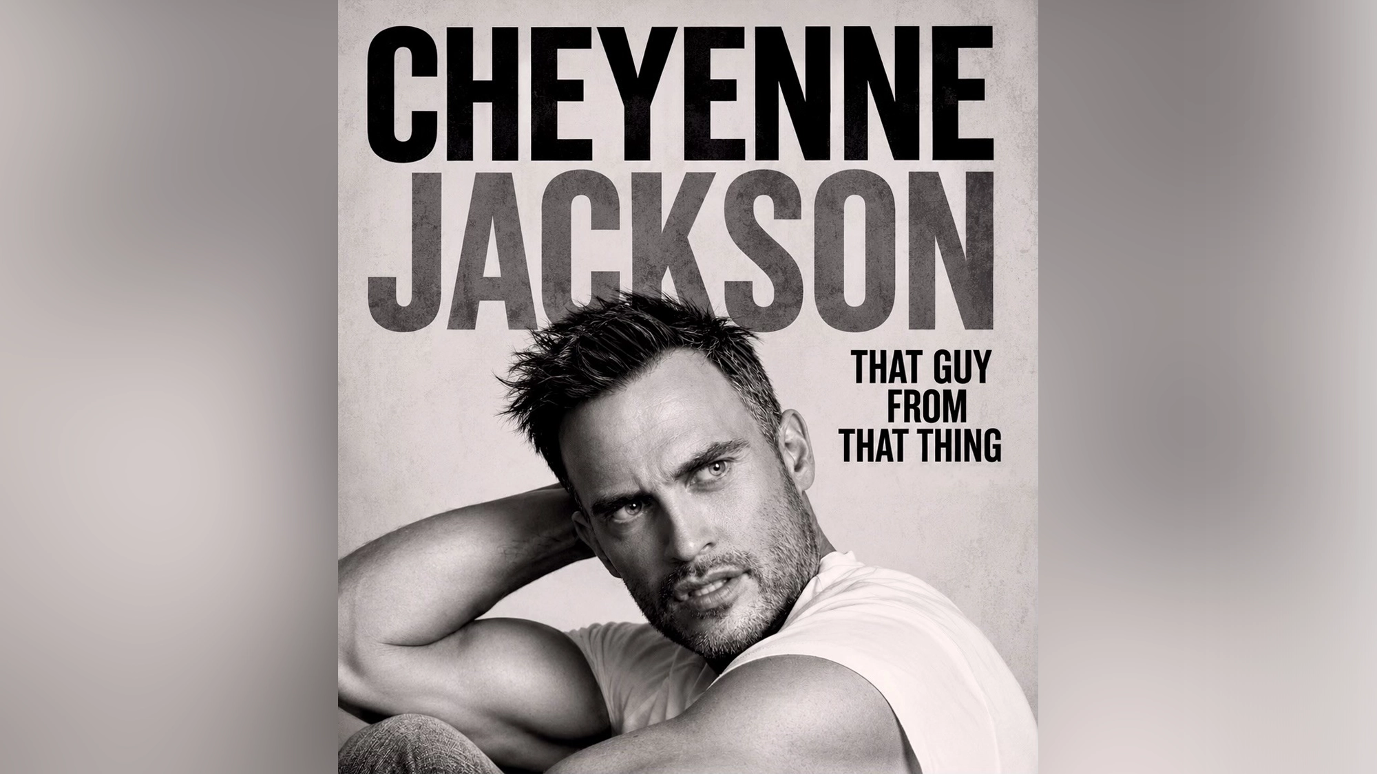 Black-and-white image of Cheyenne Jackson, short hair and stubble, leaning back with his arm on his head. Large text above reads 