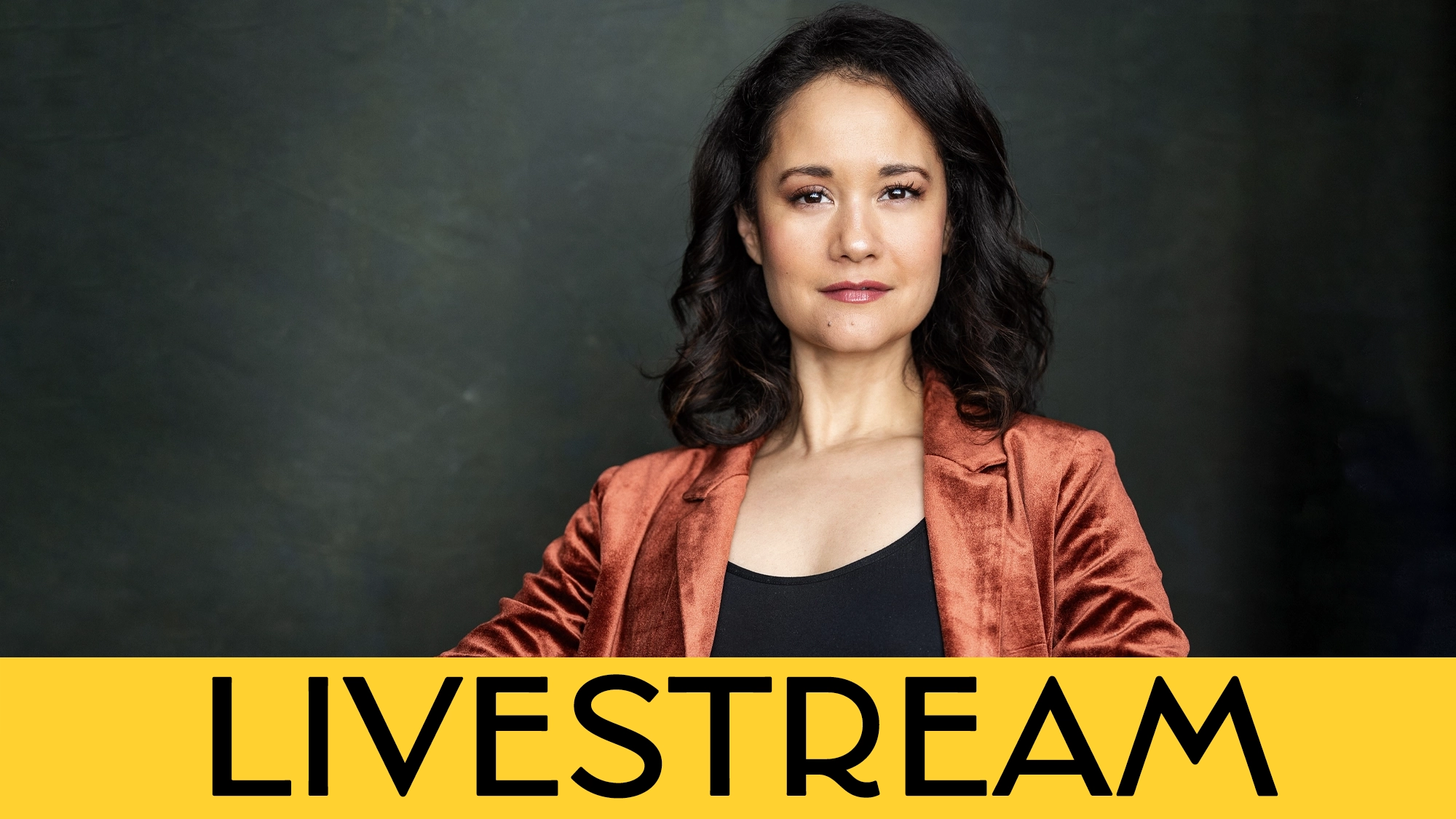A woman with wavy dark hair, wearing a copper blazer over a black top, looks confidently at the camera. The background is dark, and a bold yellow banner with the word “LIVESTREAM” in black letters is across the bottom—highlighting Ali Ewoldt’s special performance of “When You Wish Upon A Star.”.