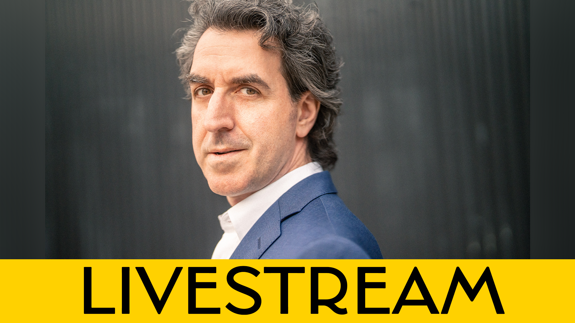 A man with wavy gray hair, wearing a blue suit, looks over his shoulder against a dark background. A yellow banner at the bottom displays the word “LIVESTREAM” in bold black letters, highlighting this special NYC broadcast.