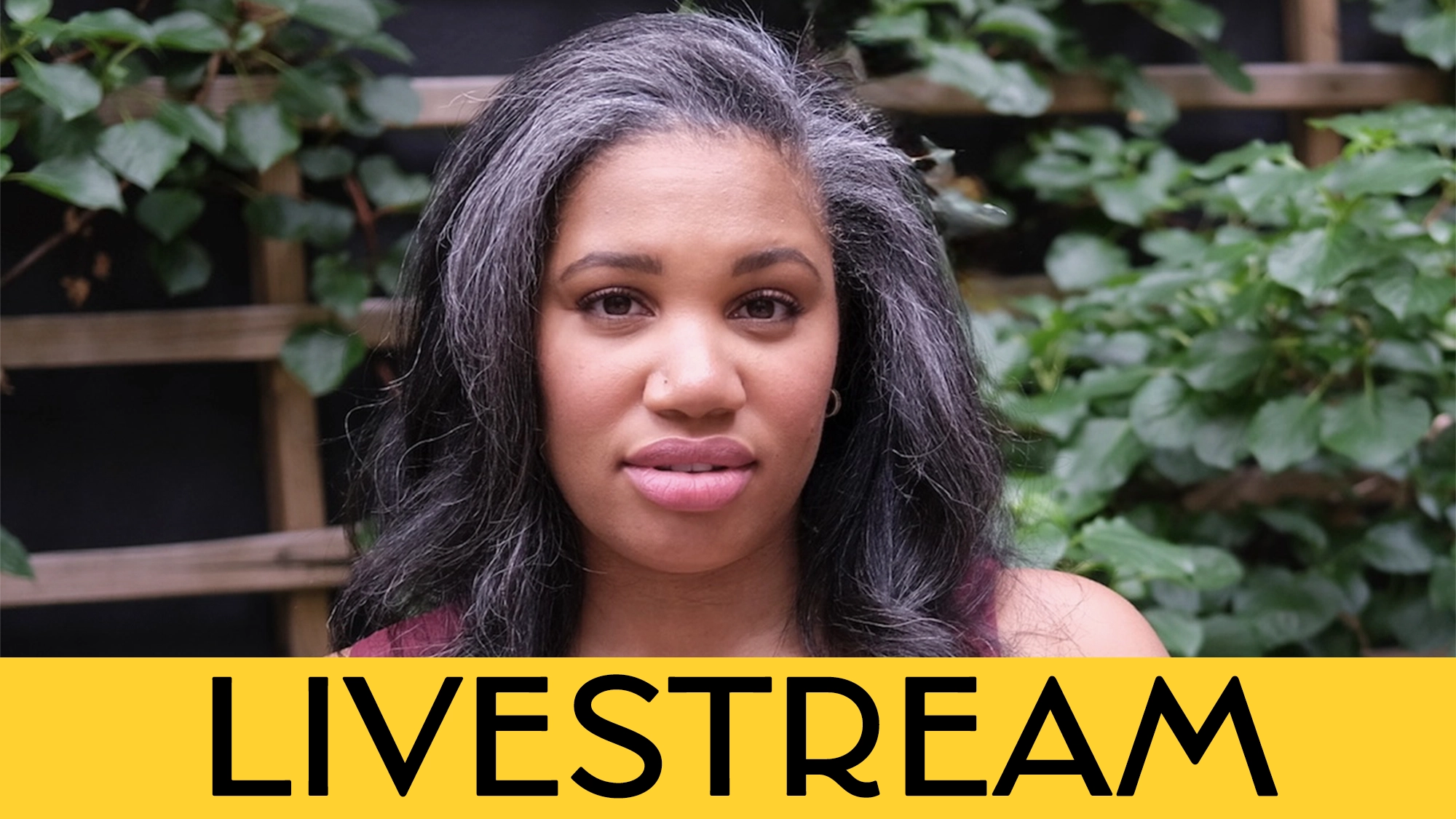 A woman with long dark hair stands outside in front of leafy plants and wooden lattice. She looks at the camera with a neutral expression. A bold yellow banner at the bottom reads “Tara Jackson LIVESTREAM” in large black letters.